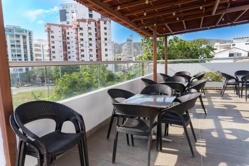 una fila de mesas y sillas en un balcón en Hotel Zamay Plus, en Santa Marta