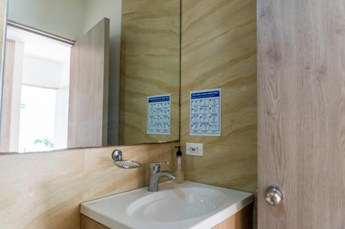 a bathroom with a sink and a mirror at Hotel Zamay Plus in Santa Marta
