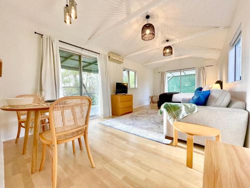 a living room with a table and a couch at Norman Lindsay Cottage in Faulconbridge