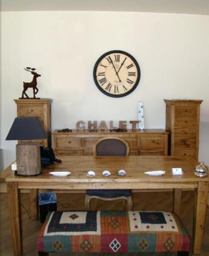 a wooden table with a clock on the wall at Styga Mountain Resort in Zarouchla