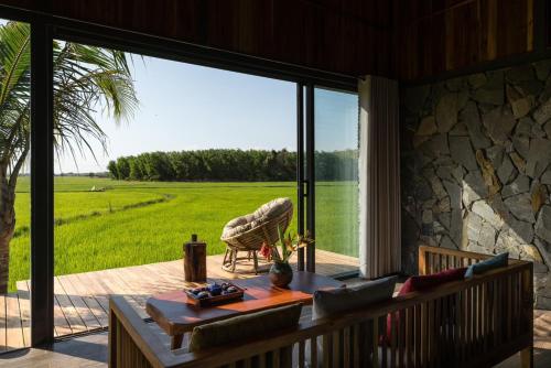 a living room with a large sliding glass door with a view at The Ruong Resort in Vung Tau