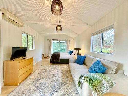a living room with a couch and a bed at Norman Lindsay Cottage in Faulconbridge