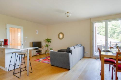 uma sala de estar com um sofá e uma mesa em Bright one-bedroom in Villeneuve-d'Ascq - Welkeys em Villeneuve d'Ascq