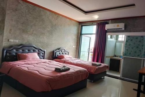 1 dormitorio con 2 camas con sábanas rojas y ventana en Pingpong Place, en Ban Non Kum
