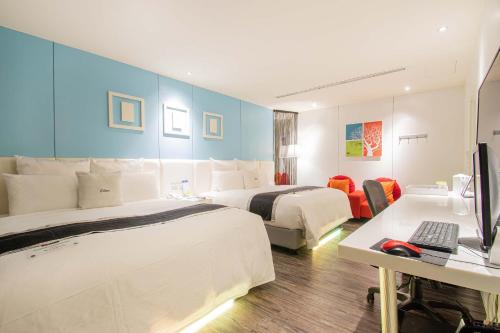 a hotel room with two beds and a desk with a computer at 168 Motel-Hsinchu in Hsinchu City