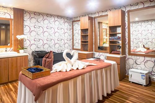a room with a bed with a basket and a mirror at DLG Hotel Danang in Da Nang