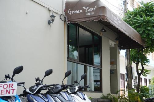 a group of scooters parked outside of a restaurant at Green Leaf Hostel in Phuket Town