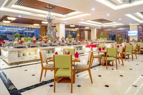a restaurant with tables and chairs and a bar at DLG Hotel Danang in Da Nang