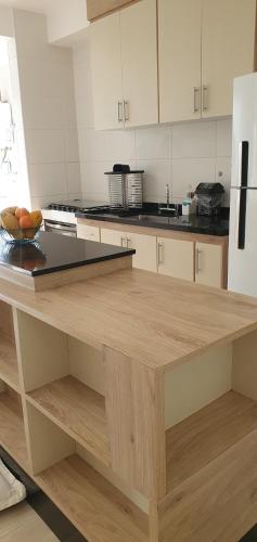 a kitchen with a wooden counter top in a kitchen at Resort Itanhaém - Pé na areia in Itanhaém