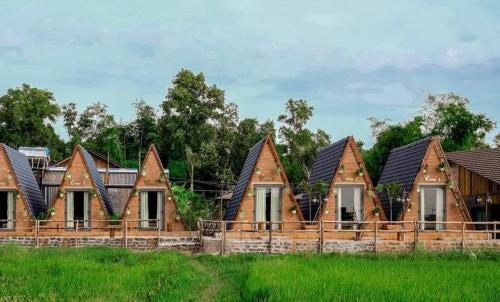 een rij huizen met daken in een veld bij The Ruong Resort in Vung Tau