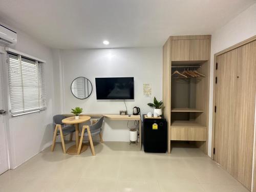 a room with a desk and a tv and a table at The Nine Place แจ้งสนิท in Ban Nong Bua