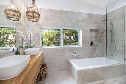 a bathroom with a tub and a sink and a shower at Oceanfront Beach House On Marine Parade in Kingscliff