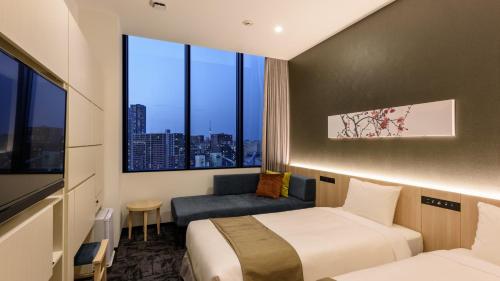 a hotel room with two beds and a window at hotel MONday Premium TOYOSU in Tokyo