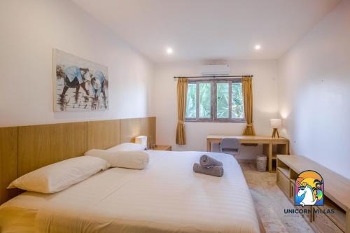 - une chambre avec un grand lit et un bureau dans l'établissement Hurley House - by Unicorn Villas Bali, à Canggu