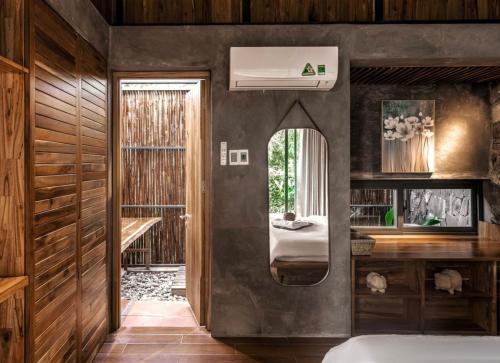 a bedroom with a mirror and a bed in it at The Ruong Resort in Vung Tau