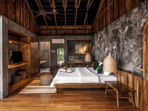a bedroom with a large bed and a table at The Ruong Resort in Vung Tau