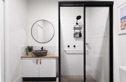 a bathroom with a sink and a mirror at Currumbin Beach 1 bedroom Studio - steps from the beach! in Gold Coast