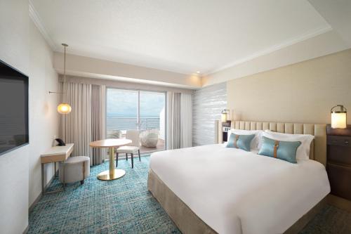 a hotel room with a bed and a view of the ocean at Kobe Meriken Park Oriental Hotel in Kobe