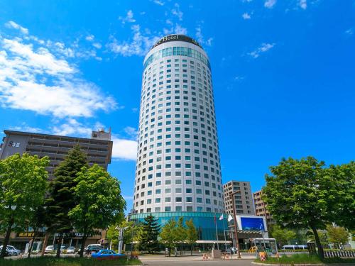 a tall white building in a city at Sapporo Prince Hotel in Sapporo
