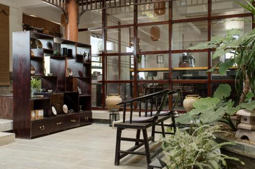 a room with a chair and some plants at Dali Yanyuan Erhai Retreat in Dali