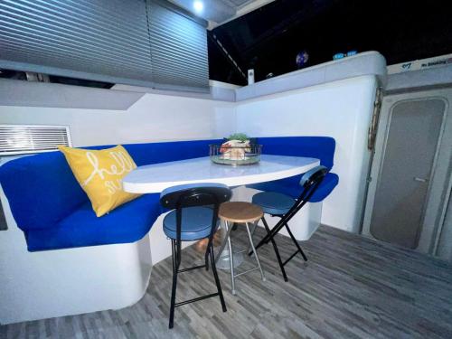 una pequeña cocina con sofá azul, mesa y taburetes en Nice Boat in Key Largo en Cayo Largo