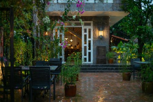 a patio with tables and chairs and plants at Amanaki Thao Dien in Ho Chi Minh City