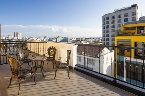 a balcony with chairs and a table on a building at Charming beauty hotel in Da Nang