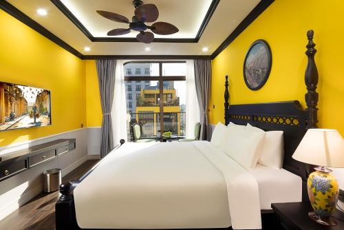 1 dormitorio con cama blanca y pared amarilla en Charming beauty hotel en Da Nang