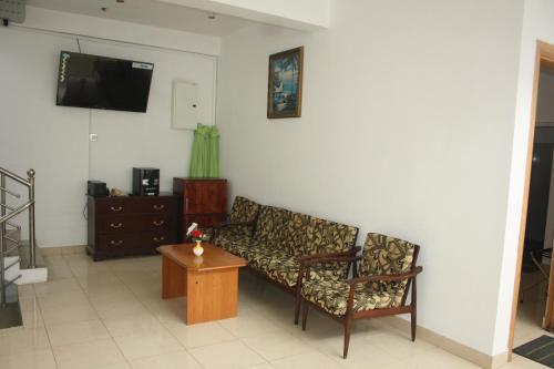 sala de estar con sofá y mesa en kandywin Hotels, en Kandy