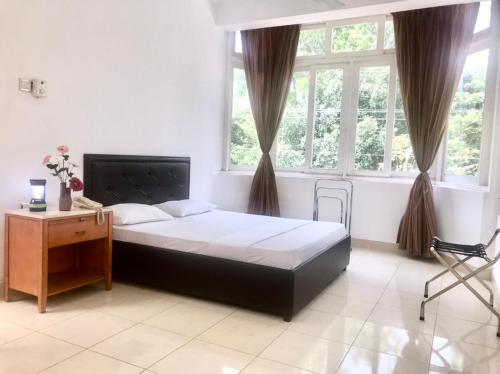 1 dormitorio con 1 cama, escritorio y ventanas en kandywin Hotels, en Kandy