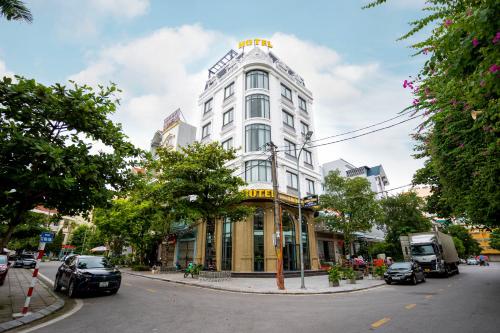 a white building on the corner of a street at Hotel Trung Duong in Móng Cái