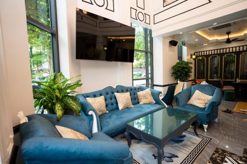 a living room with blue couches and a glass table at Hotel Trung Duong in Móng Cái