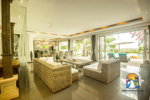 een woonkamer met 2 stoelen en een tafel bij Villa Black Pearl - by Unicorn Villas Bali in Padangbai