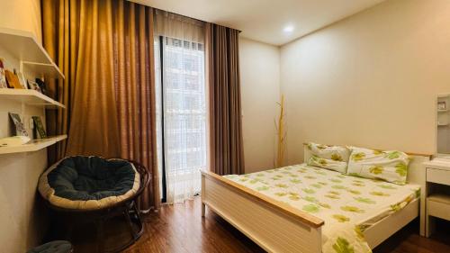 um quarto com uma cama, uma cadeira e uma janela em Homestay Times City Luxury 01T1N em Hanói