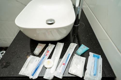 a bathroom counter with toothbrushes and toothpaste on it at Hotel Trung Duong in Móng Cái