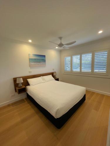 a bedroom with a bed and a ceiling fan at Seashells Beachfront Resort in Diamond Beach