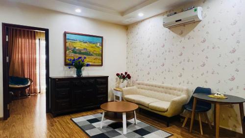 uma sala de estar com um sofá e uma mesa em Homestay Times City Luxury 01T1N em Hanói