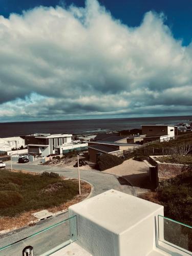 a view of a town with buildings and the ocean at Yzerfontein Villa Fantastica - No Loadshedding in Yzerfontein