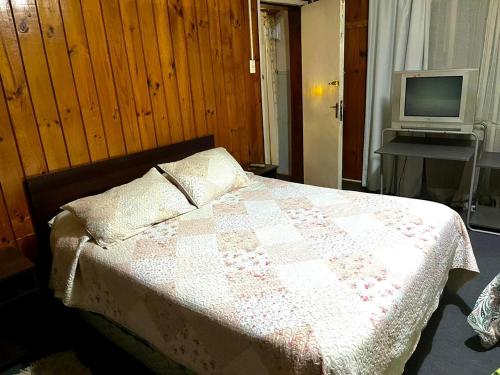 una camera con letto e TV su un tavolo di Hospedaje Centro Valdivia a Valdivia