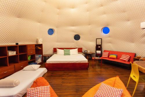 a room with two beds and a couch in it at Bitzu Dome-Bijagua Riverside Glamping in Bijagua