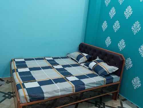a bed in a room with a blue wall at Laxman Guest House in Varanasi