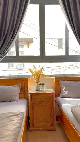a bedroom with two beds and a window at Khoảng Lặng ATP in Da Lat