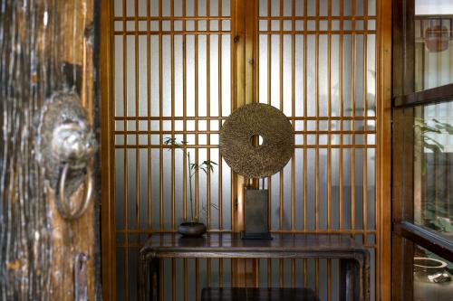 a room with a bamboo wall with a table and a mirror at Dali Yanyuan Erhai Retreat in Dali