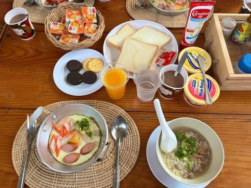 a table with plates of food and bowls of soup at บ้านเนวี่ เกาะล้าน in Ko Larn