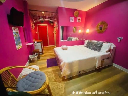 a pink bedroom with a large bed and a tv at บ้านเนวี่ เกาะล้าน in Ko Larn