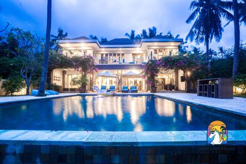 een groot huis met een zwembad ervoor bij Villa Black Pearl - by Unicorn Villas Bali in Padangbai