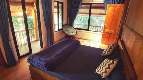een slaapkamer met een bed in een kamer met ramen bij Giang House in Hòa Bình