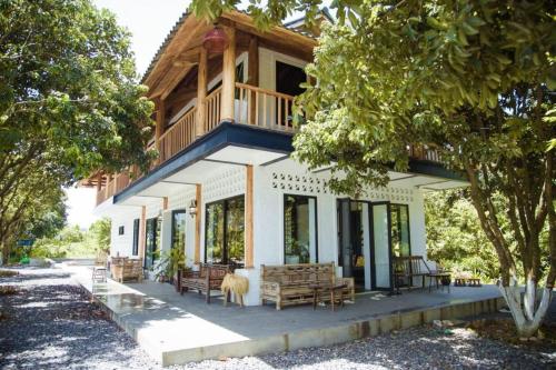 a house with a porch with benches on it at Giang House in Hòa Bình