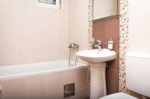 y baño con lavabo, aseo y bañera. en Apartments LILA AUREA en Petrovac na Moru