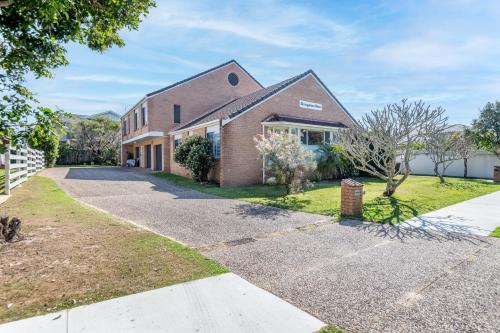 a large brick house with a driveway at Sawtell Beachfront Villa - 2 mins to everything! in Sawtell
